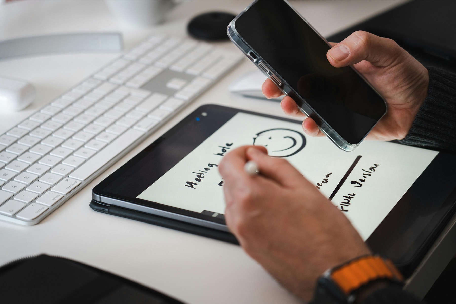 A digital household planning setup with tablet, phone, and stylus for bills and family scheduling.